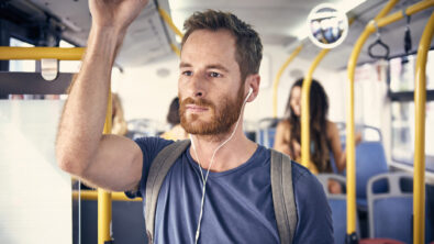 一个戴着耳机的年轻人在公交车上的照片