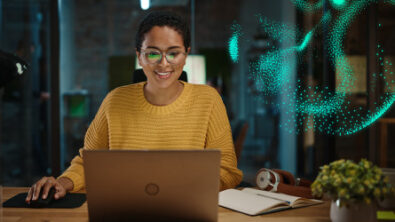 使用云解决方案的女人在笔记本电脑上工作，上面覆盖着数字叠加粒子效果